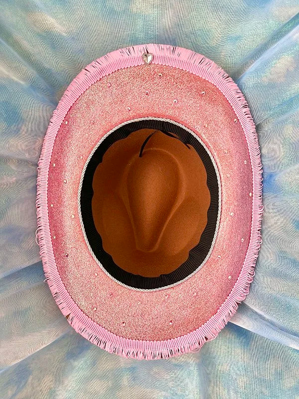 Underside of cherry blossom cowboy hat featuring sealed pink glitter and silver trim.