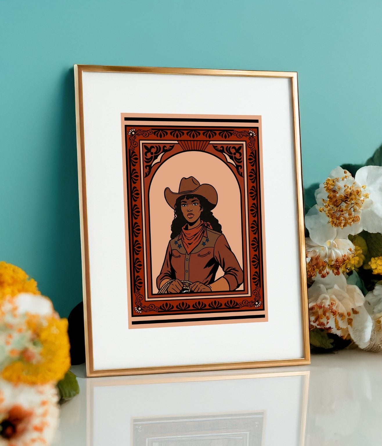 Cowgirl illustration displayed in gold frame on marble stand with teal green background and orange flowers.