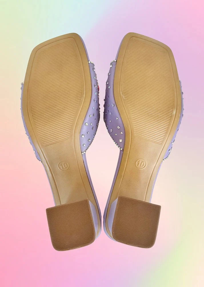 Bottom soles of lavender kitten heels displaying tread and size marking.