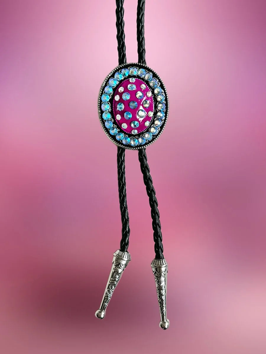 Front view of the Midnight Jewel Bolo Tie with magenta pendant and blue iridescent rhinestones on black braided rope.
