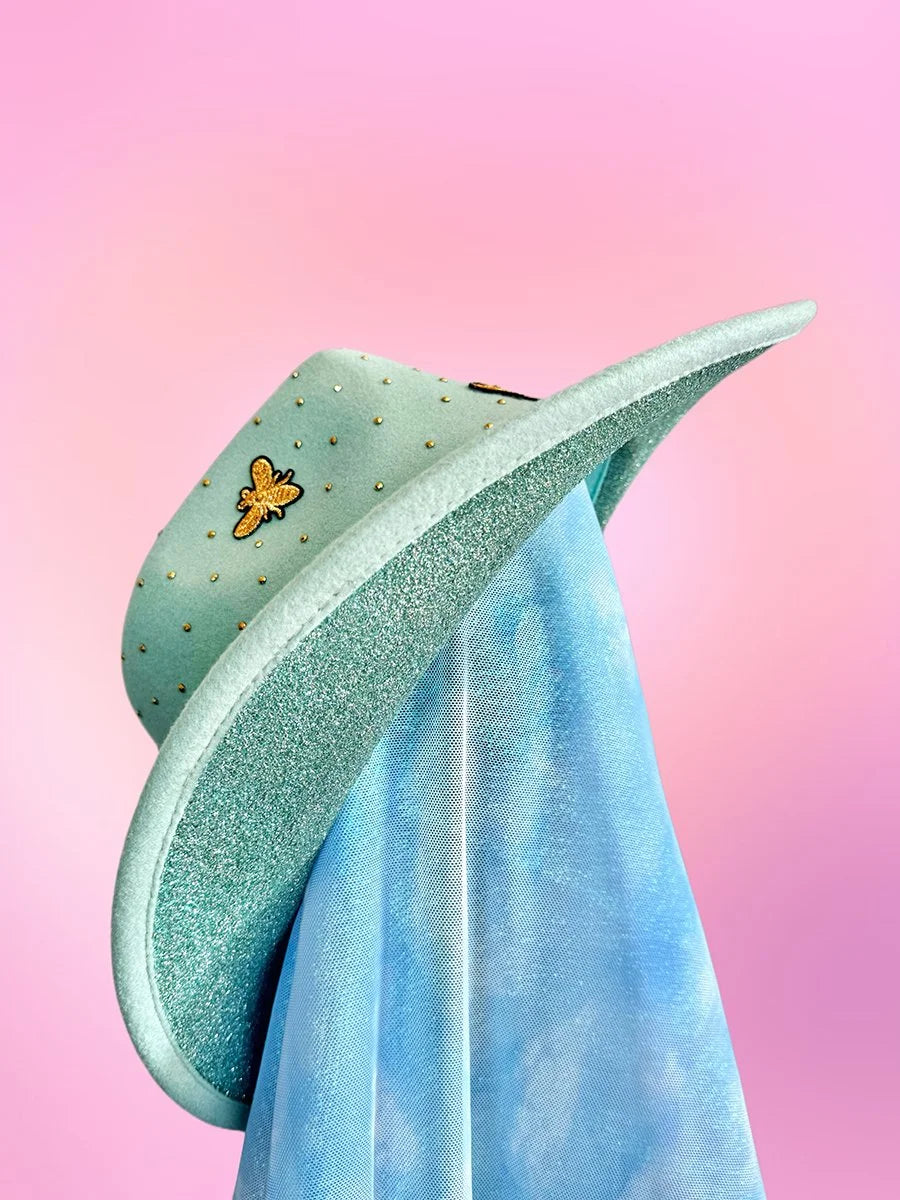 Mint green cowboy hat showing glitter underside and gold trim along the brim.