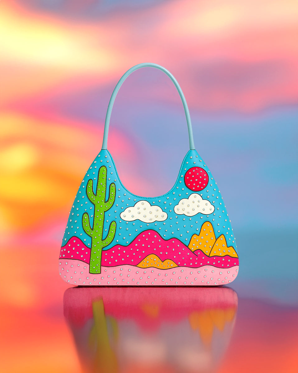 Front view of hand-painted blue desert handbag with rhinestone accents and zipper closure.