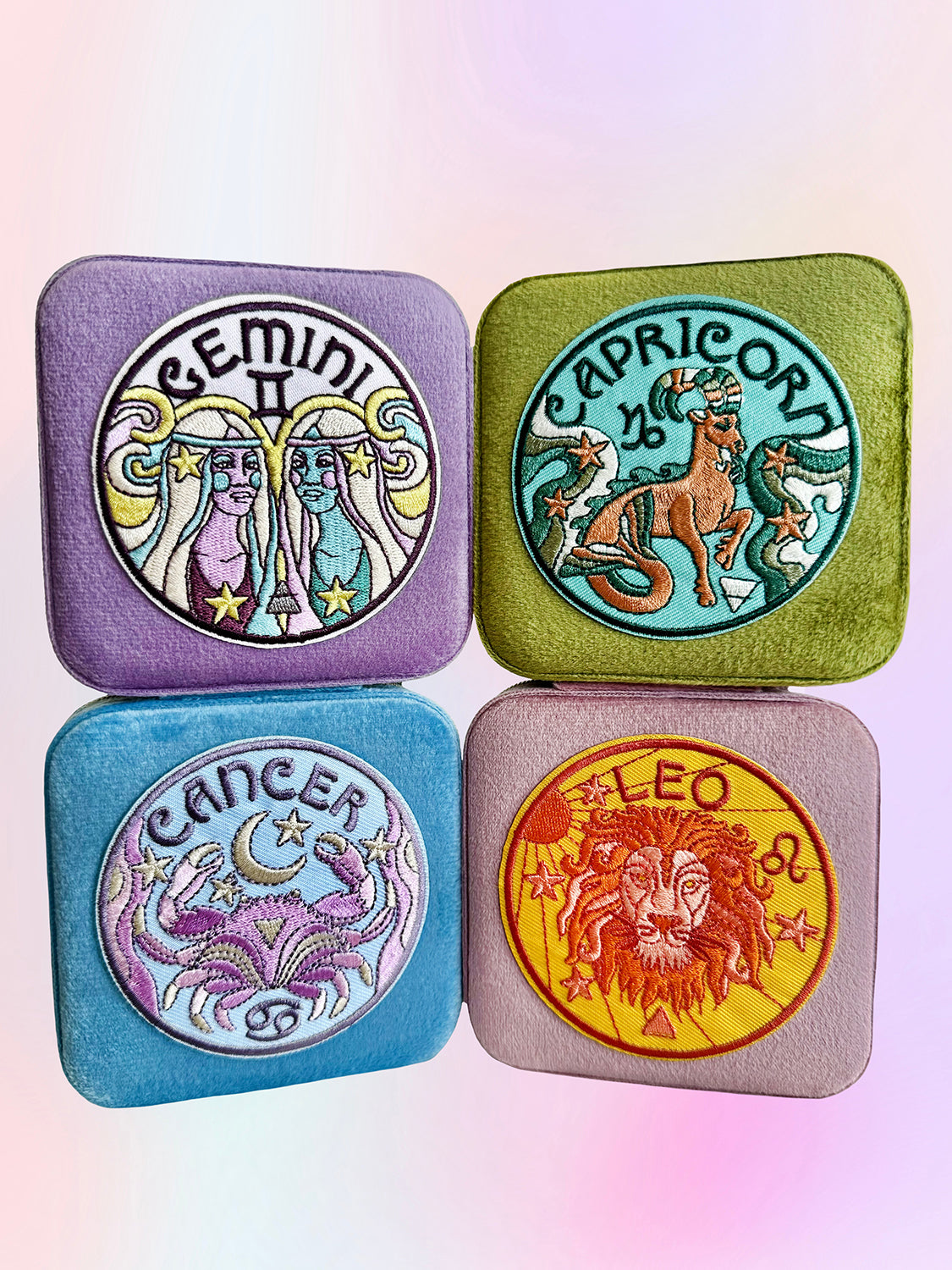 Four zodiac-themed jewelry cases with Gemini, Capricorn, Cancer, and Leo illustrations on the front of the boxes.