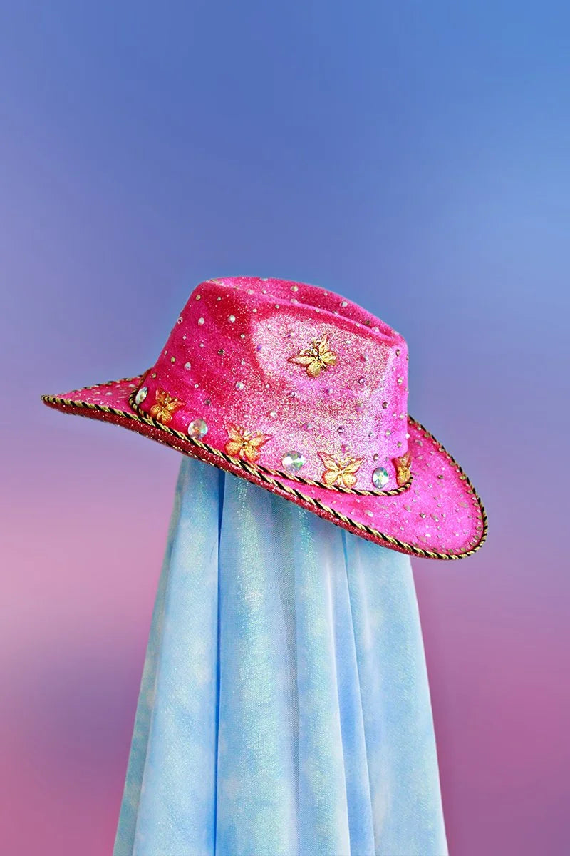 Magenta cowboy hat with butterflies, rhinestones, and black-and-gold trim, side view.