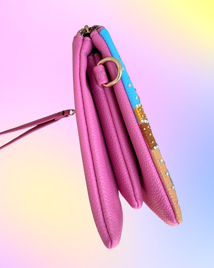 Side profile of wristlet showing layered compartments and gold hardware.
