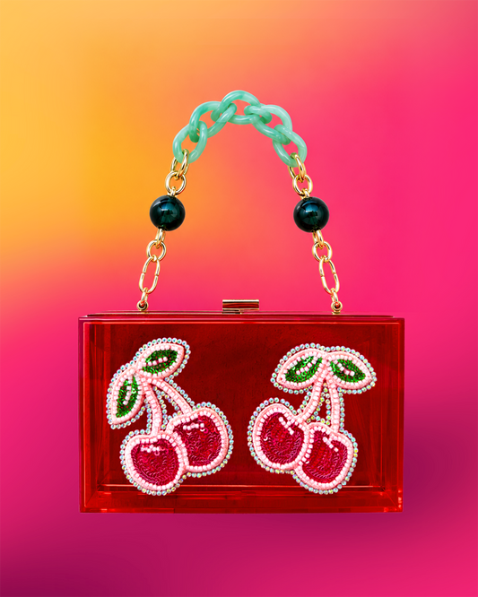 Red acrylic clutch with cherry motif.