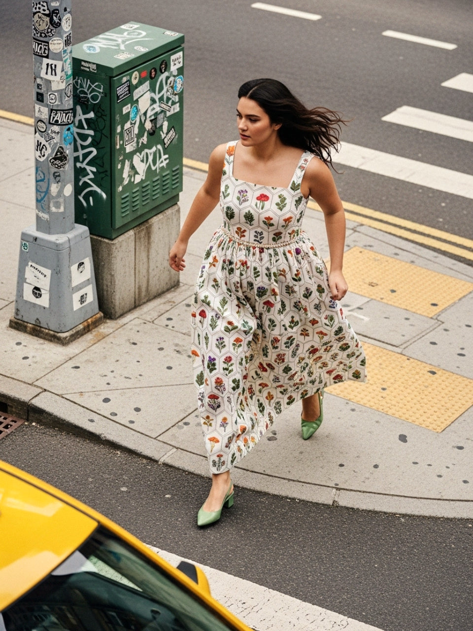 Model wearing off white maxi dress with multicolor plant and mushroom print walking in city street.