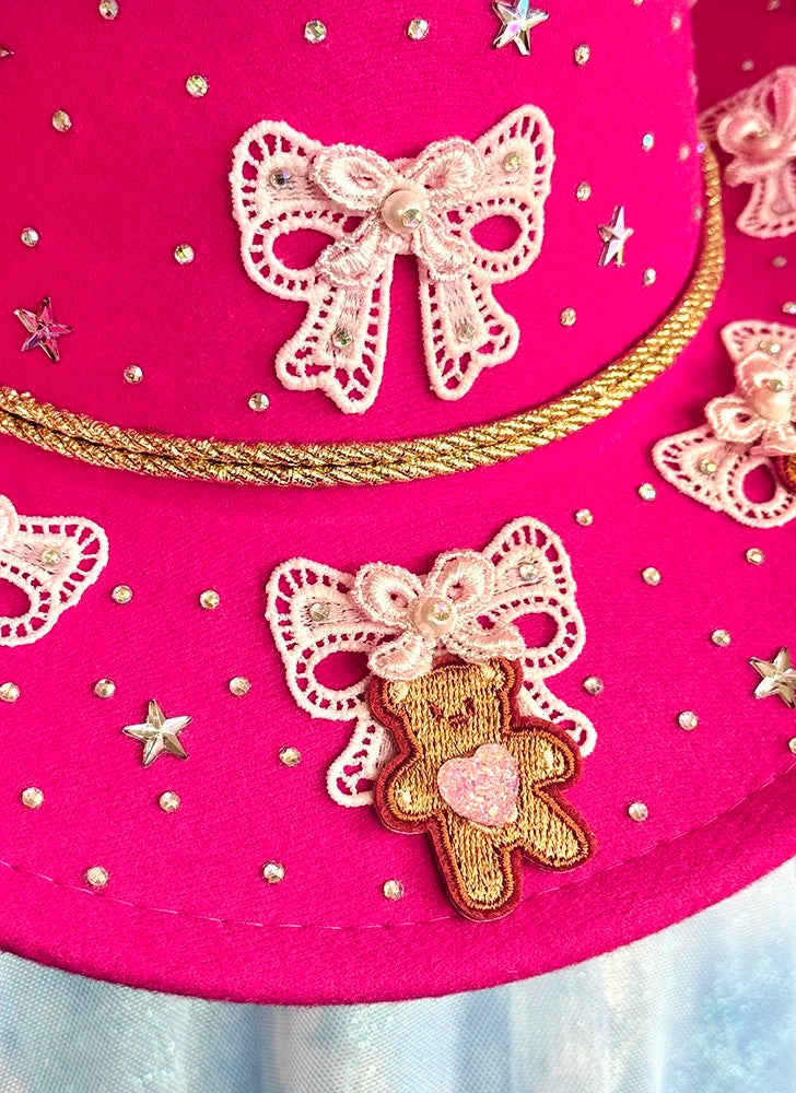 Magenta cowboy hat details with lace bows, teddy bear appliqués, and rhinestones.