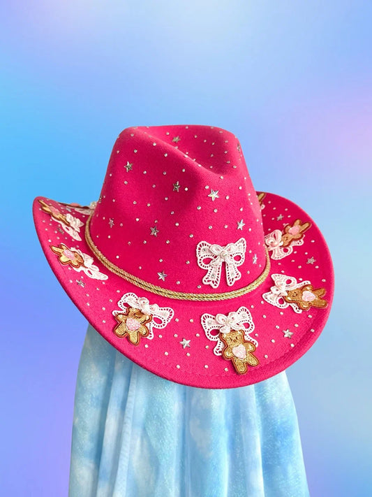 Magenta cowboy hat with lace bows, teddy bear appliqués, and rhinestones.