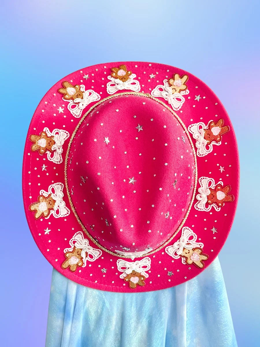 Hot pink cowgirl hat with teddy bears and decorative embellishments.