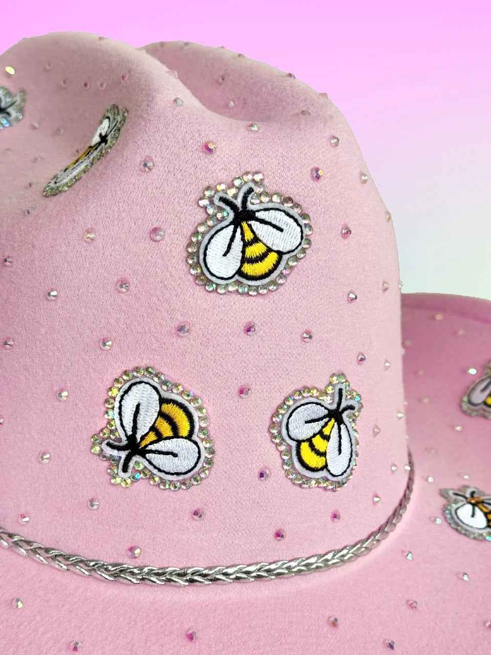 Pink cowboy hat featuring rhinestones and embroidered bee embellishments.