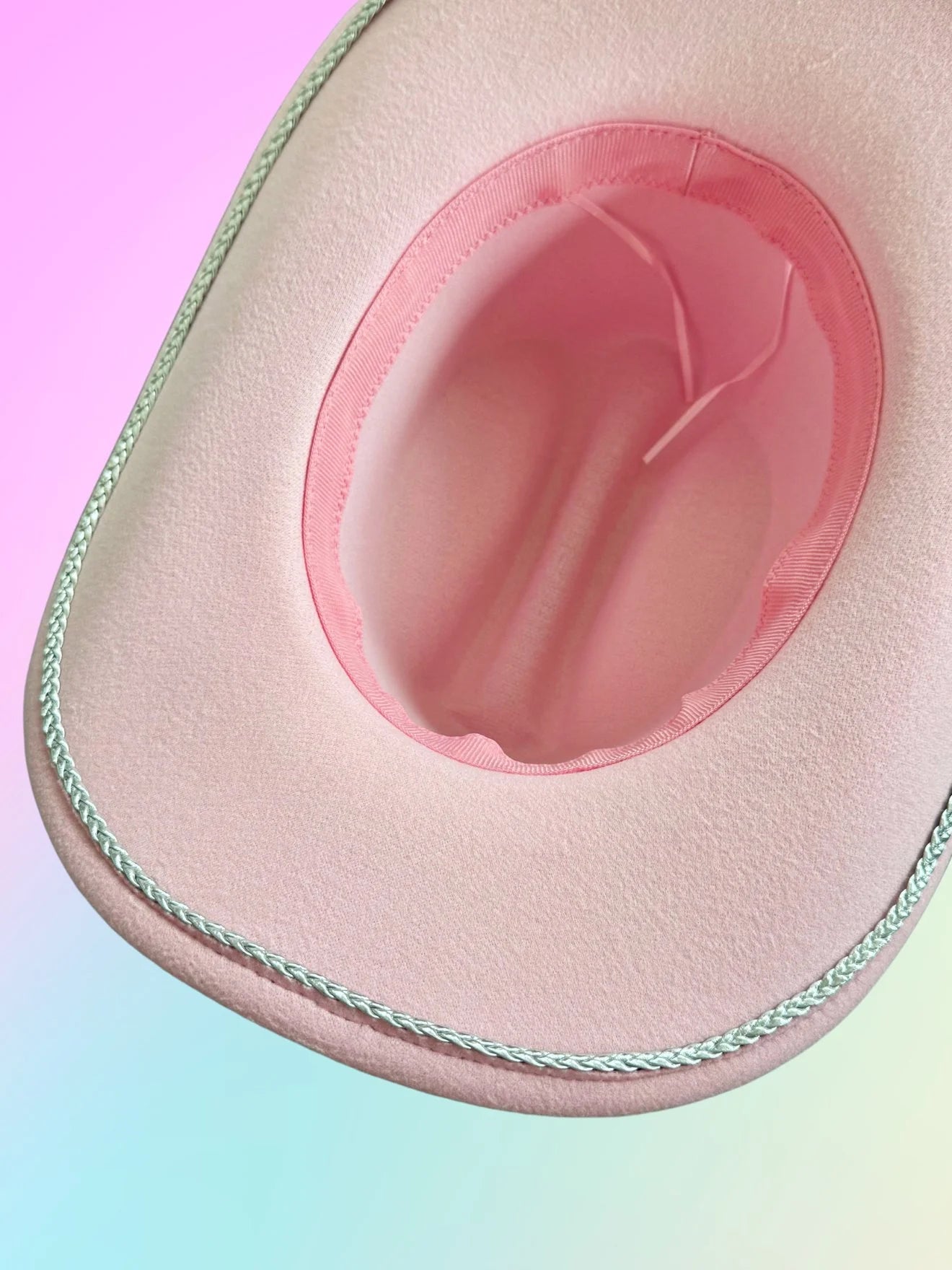 Pink cowboy hat underside with silver trim and soft interior lining.