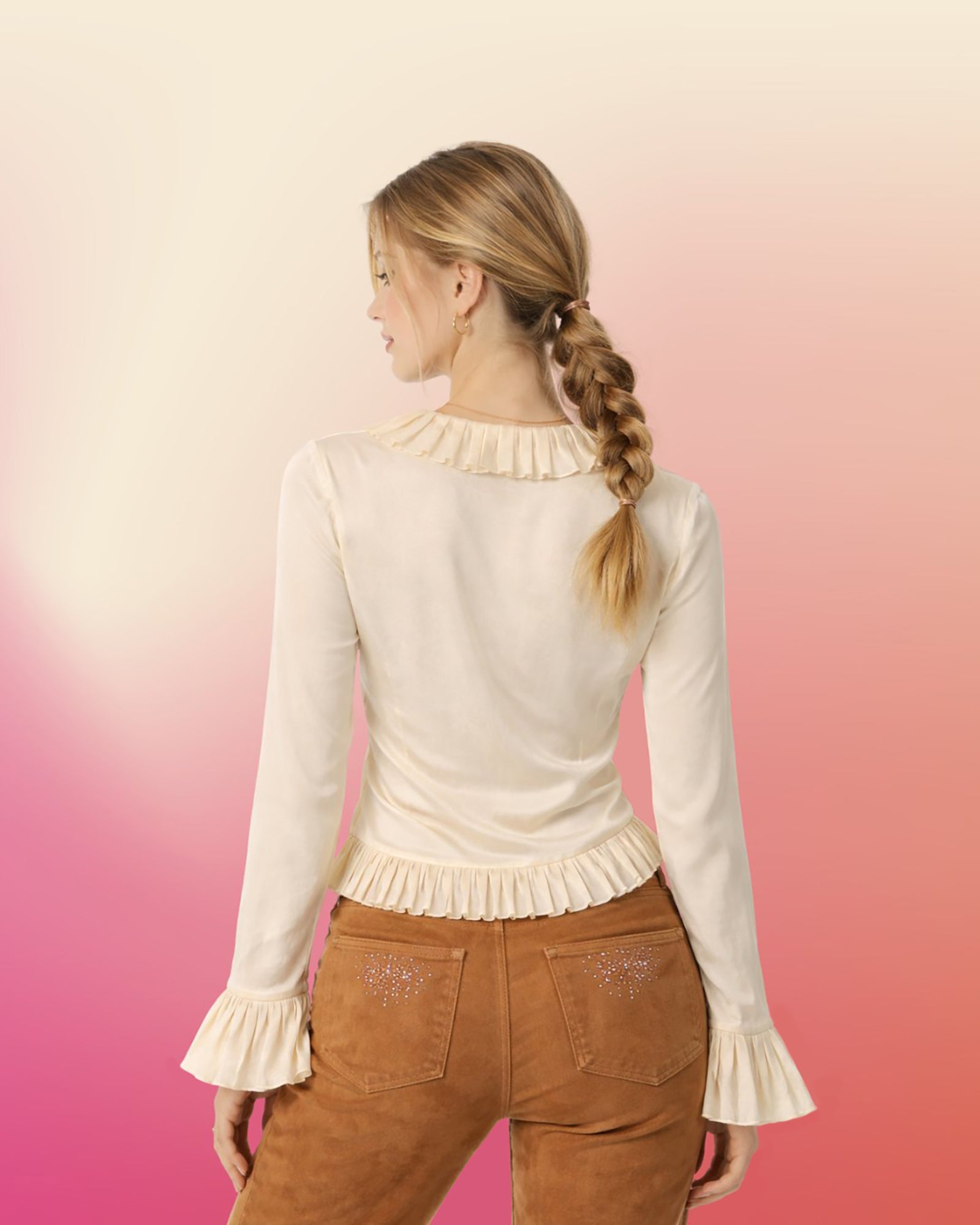 Back view of cream silk ruffle blouse showing smooth silk back, pleated collar, and ruffled hem.