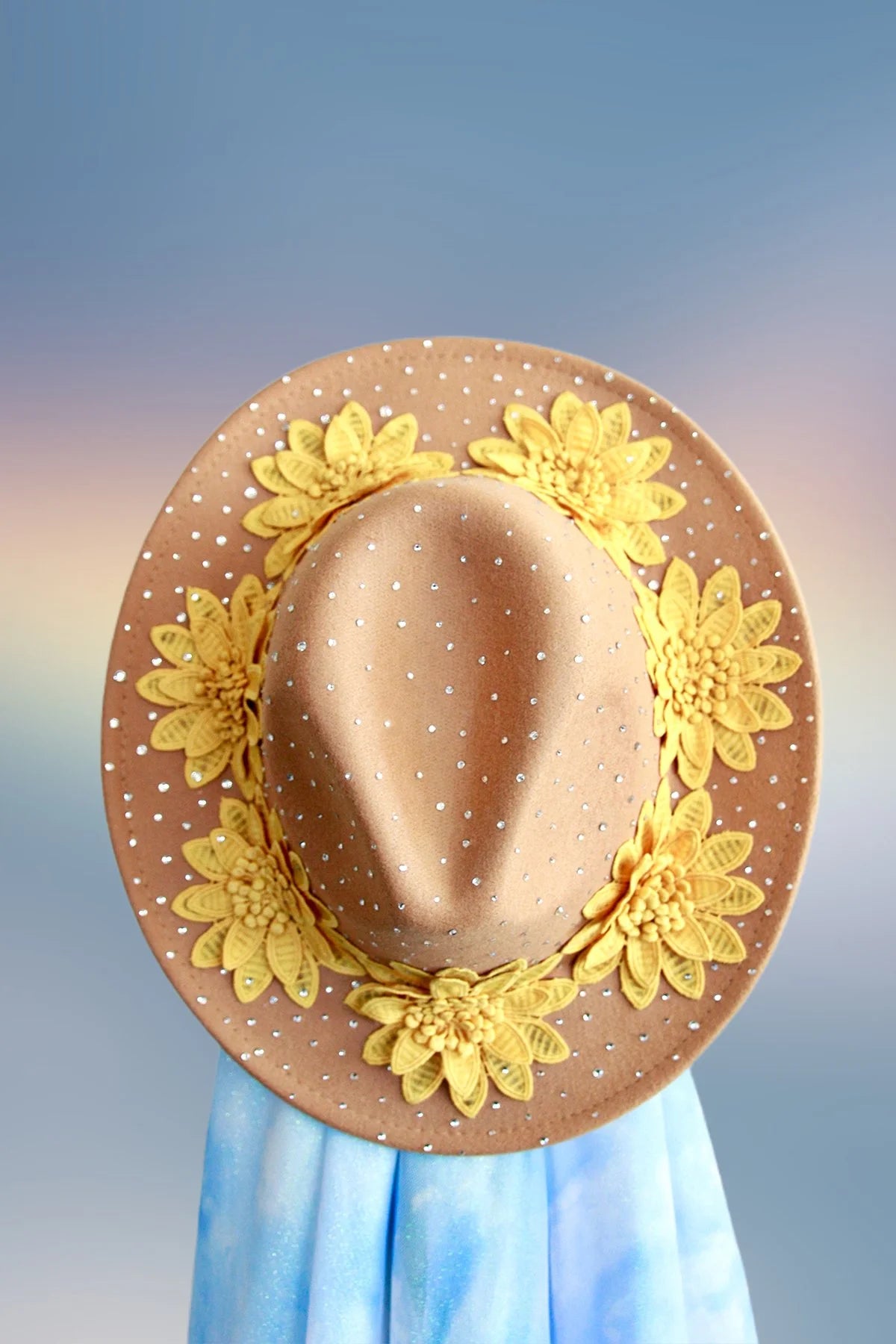 Top view of tan fedora with bronze glitter underbrim and rhinestone accents.