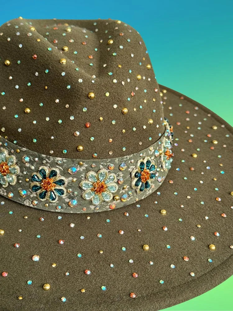 Close-up of floral beaded hat band and rhinestone details on forest green fedora.