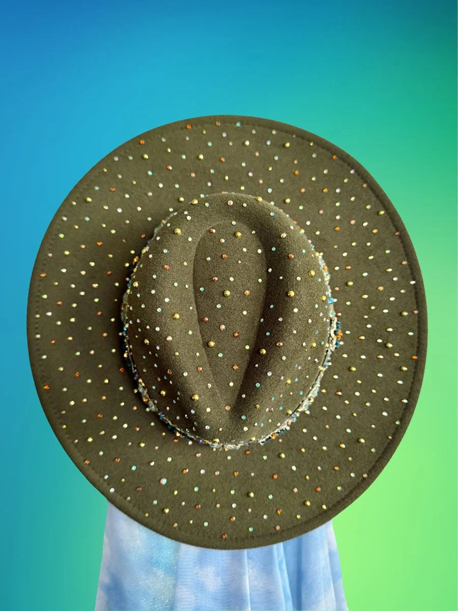 Top view of forest green fedora covered in multicolor rhinestones against gradient background.