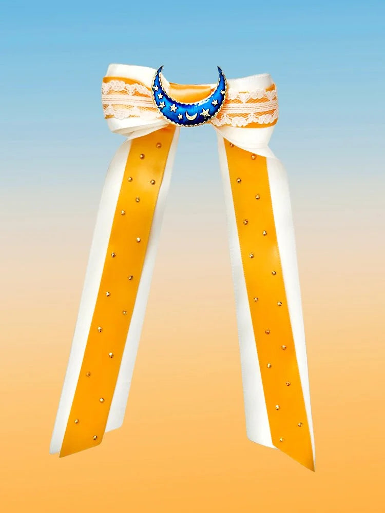 Front view of the Moonlight Magic hair bow with white and yellow layered ribbons, lace accents, crescent moon brooch, and gold rhinestones.