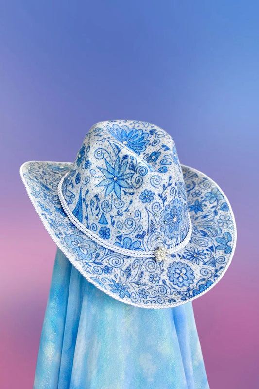 Front view of the Porcelain cowboy hat in white with blue porcelain-inspired designs, rhinestones, and glitter detailing.