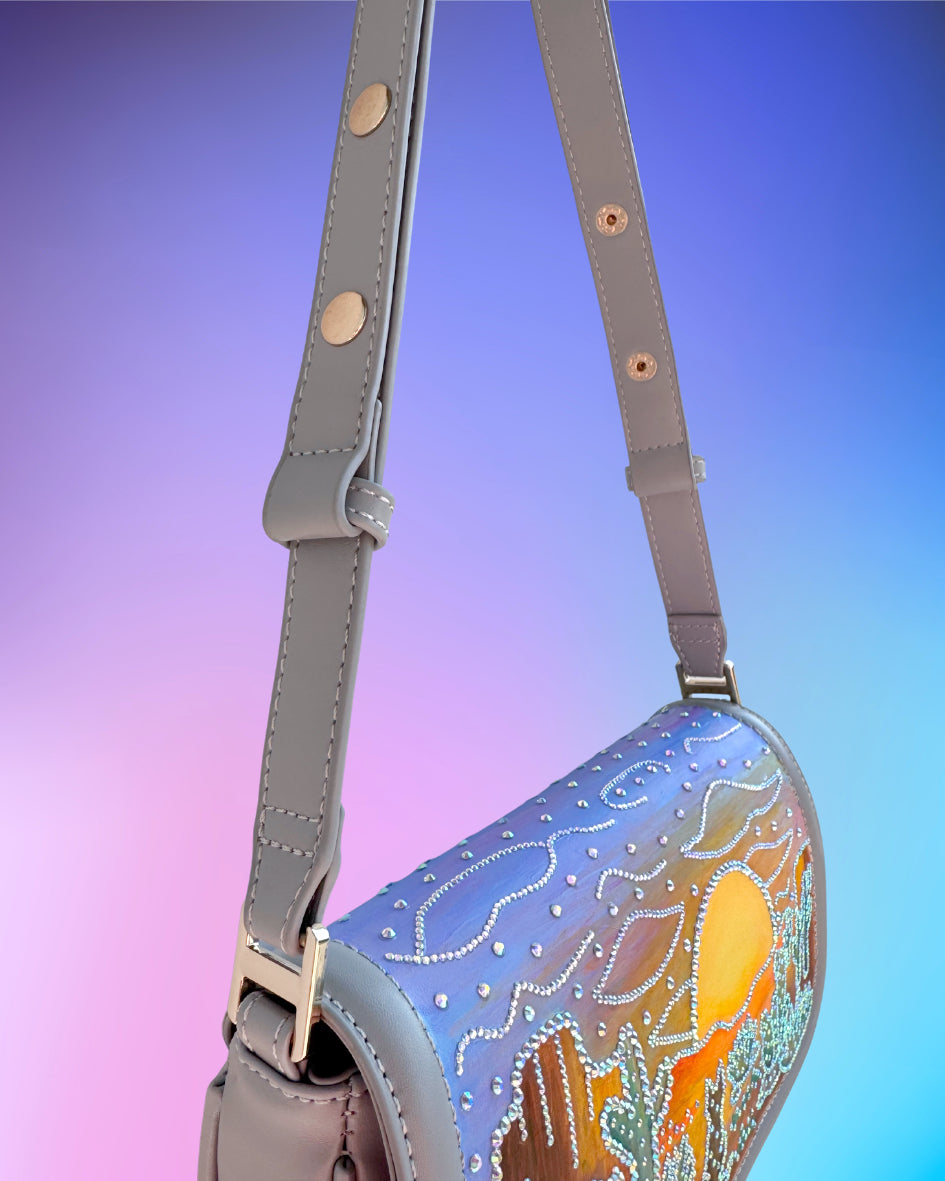 Close up of the adjustable grey strap with gold hardware.