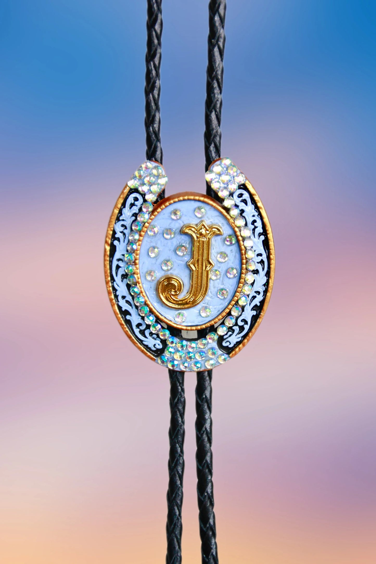 Front view of the hand-painted horseshoe pendant with gold “J,” scrollwork accents, and iridescent rhinestones.