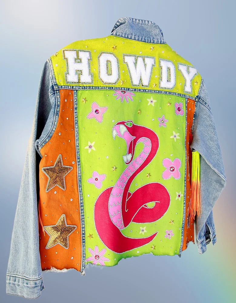 Back view of hand-painted denim jacket featuring neon green panel, pink snake artwork, and “Howdy” chenille lettering.