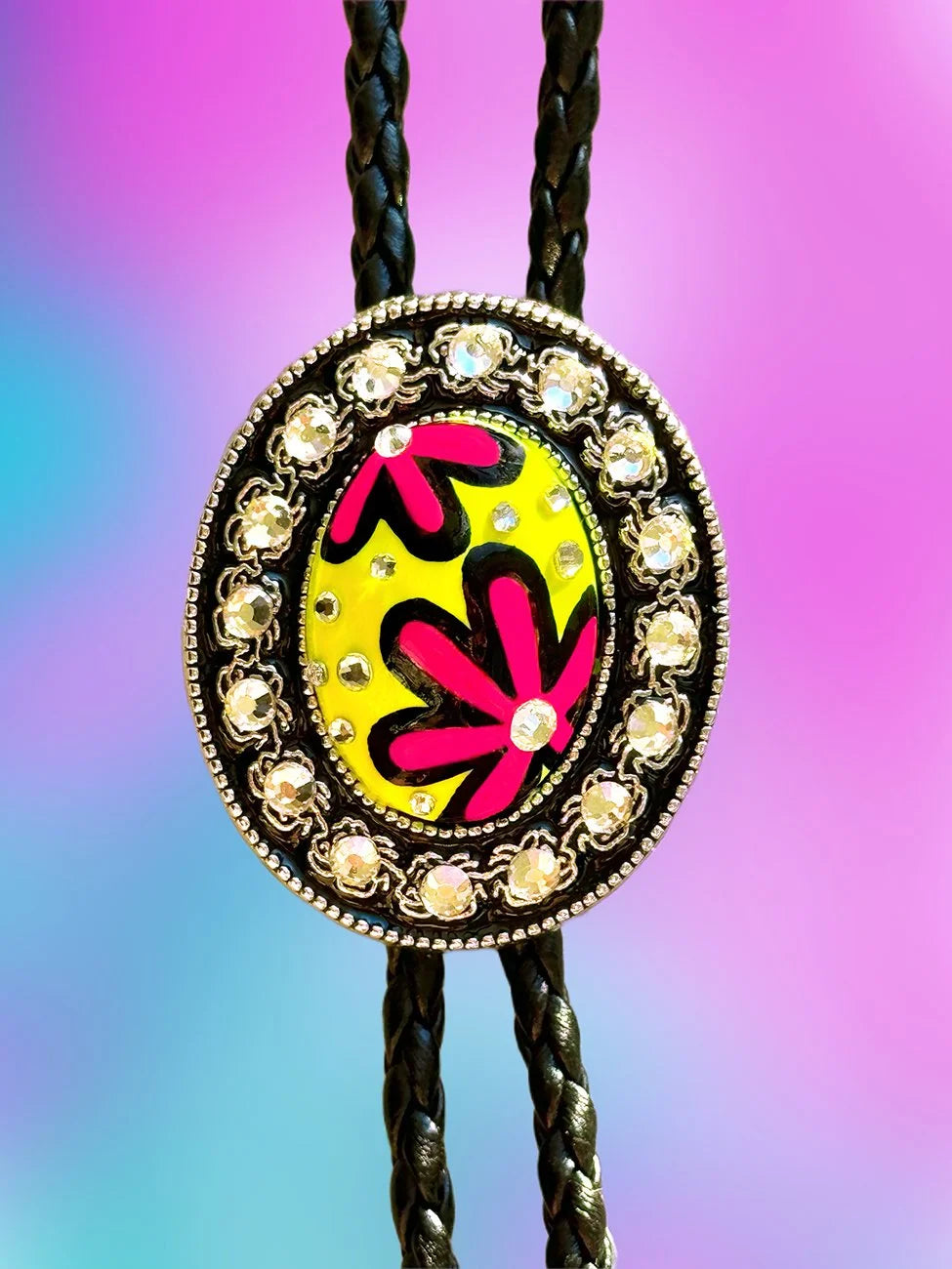 Close-up of the Jellyfish Jam Bolo Tie pendant featuring yellow paint, deep pink abstract shapes, and silver rhinestones.