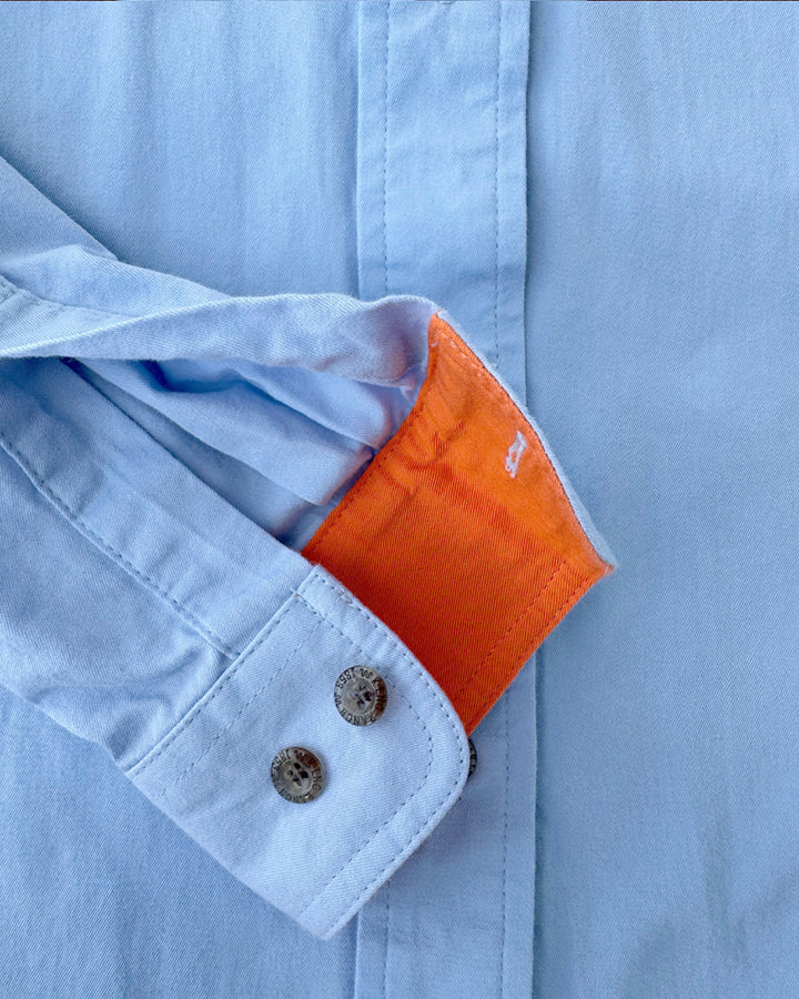 Detailed close-up of the King Ranch shirt’s orange cuff lining and metal button accents.