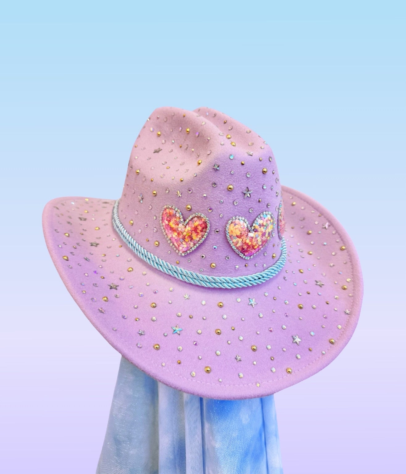 Lavender sweetheart cowboy hat decorated with rhinestones and sequin heart patches on the crown.