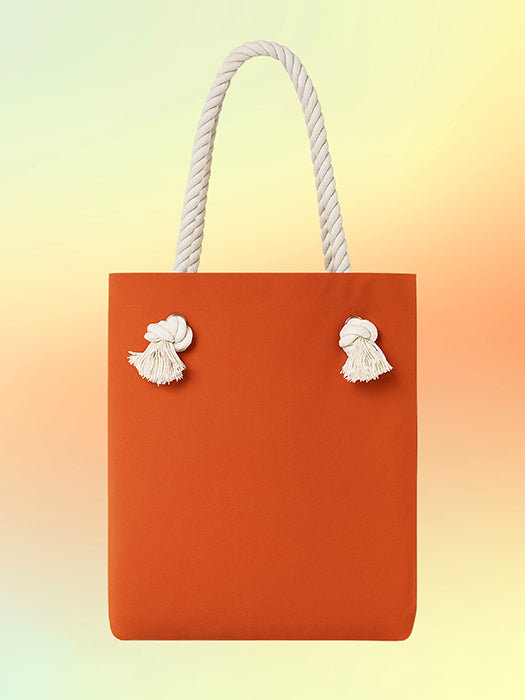 Back view of the Luna Mesa Tote featuring burnt orange canvas and knotted rope handles.