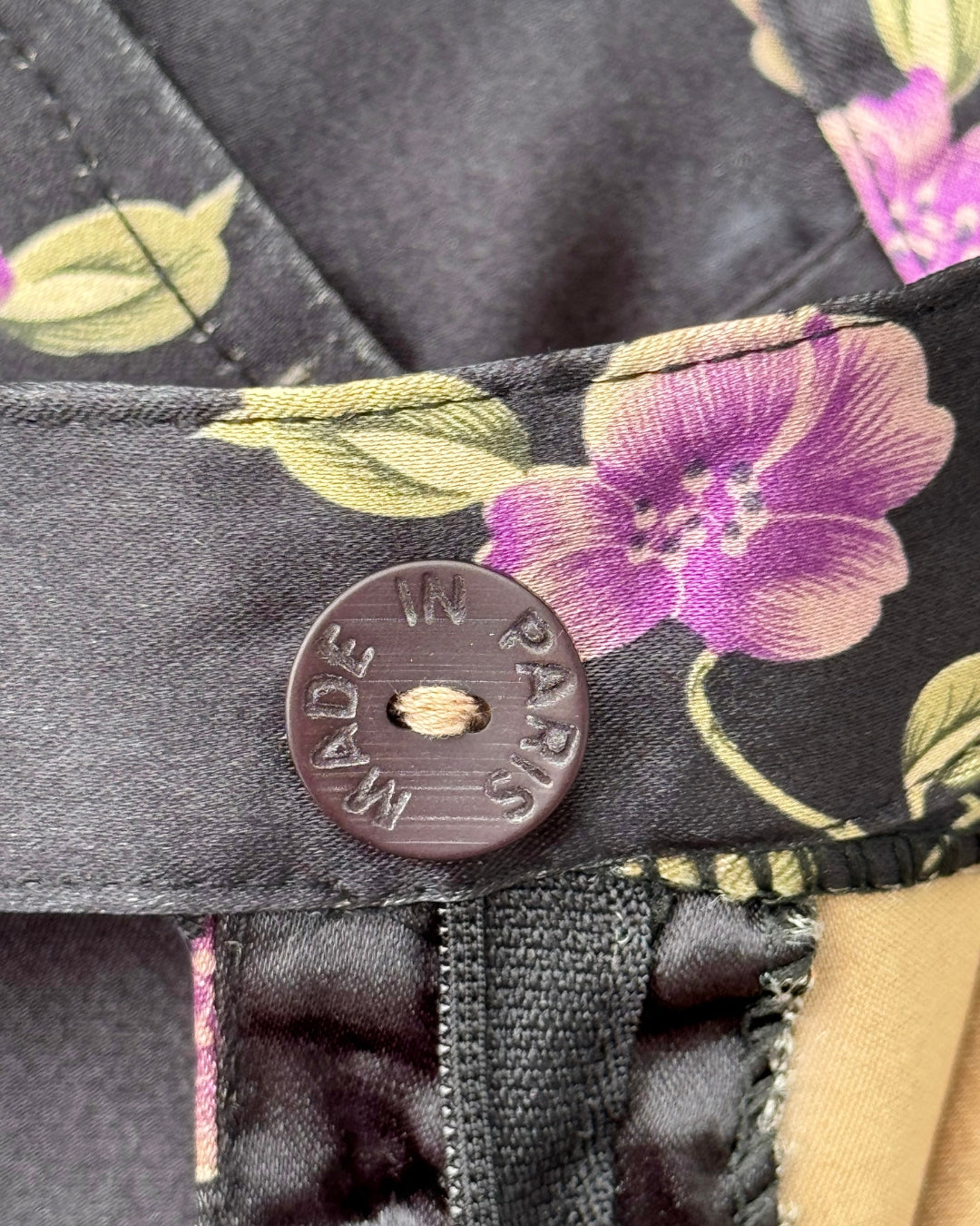 Close-up of Made in Paris button on vintage 1990s floral satin capri pants.