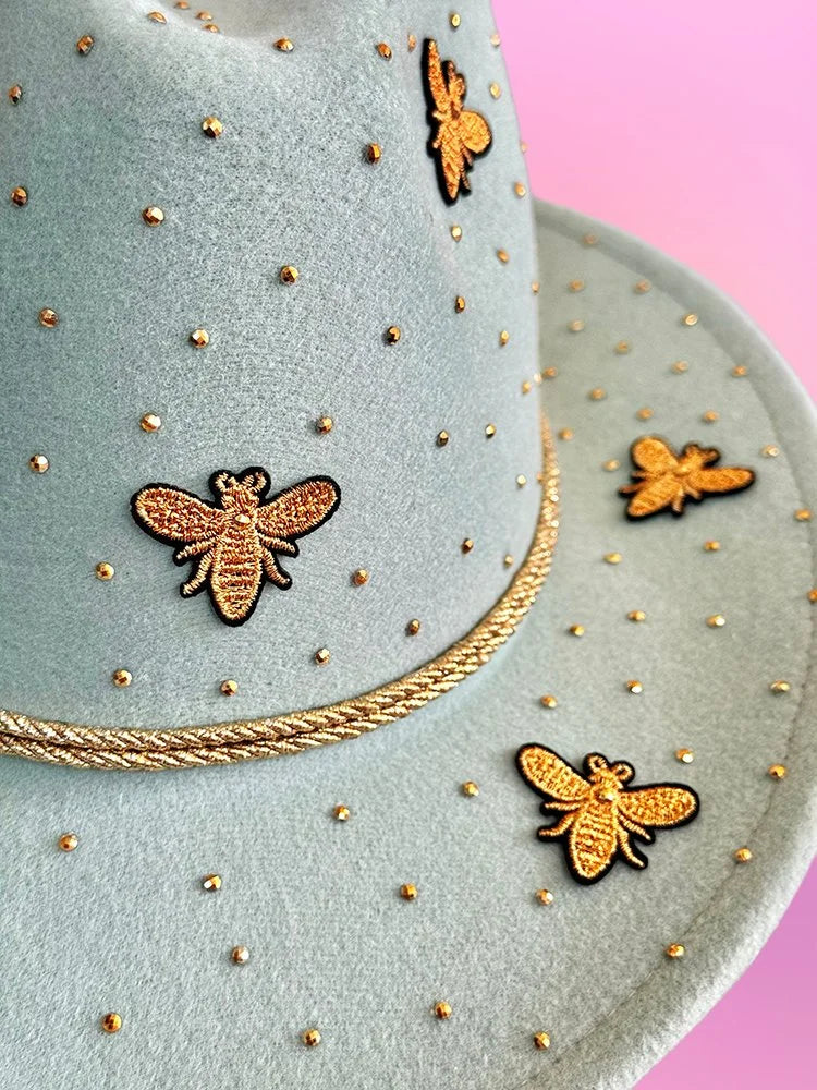 Mint green cowboy hat with gold bee appliqués and rhinestone detailing on the crown and brim.