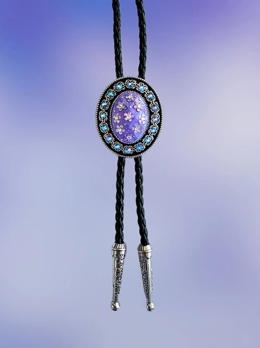 Front view of the Moonlit Violet Bolo Tie with violet floral pendant, purple rhinestones, and silver tips on braided black rope.