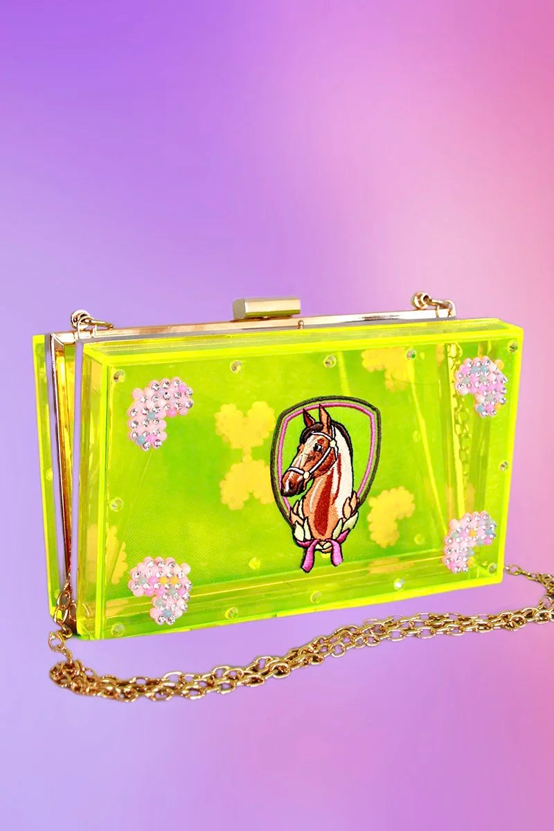 Angled view of neon-green clutch highlighting rhinestone floral clusters and acrylic shine.