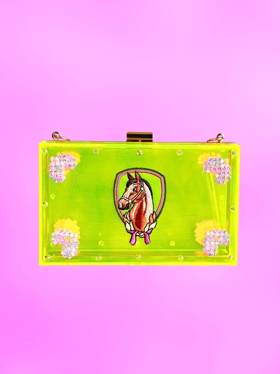 Front view of neon-green acrylic clutch with embroidered pony emblem and rhinestone floral details.
