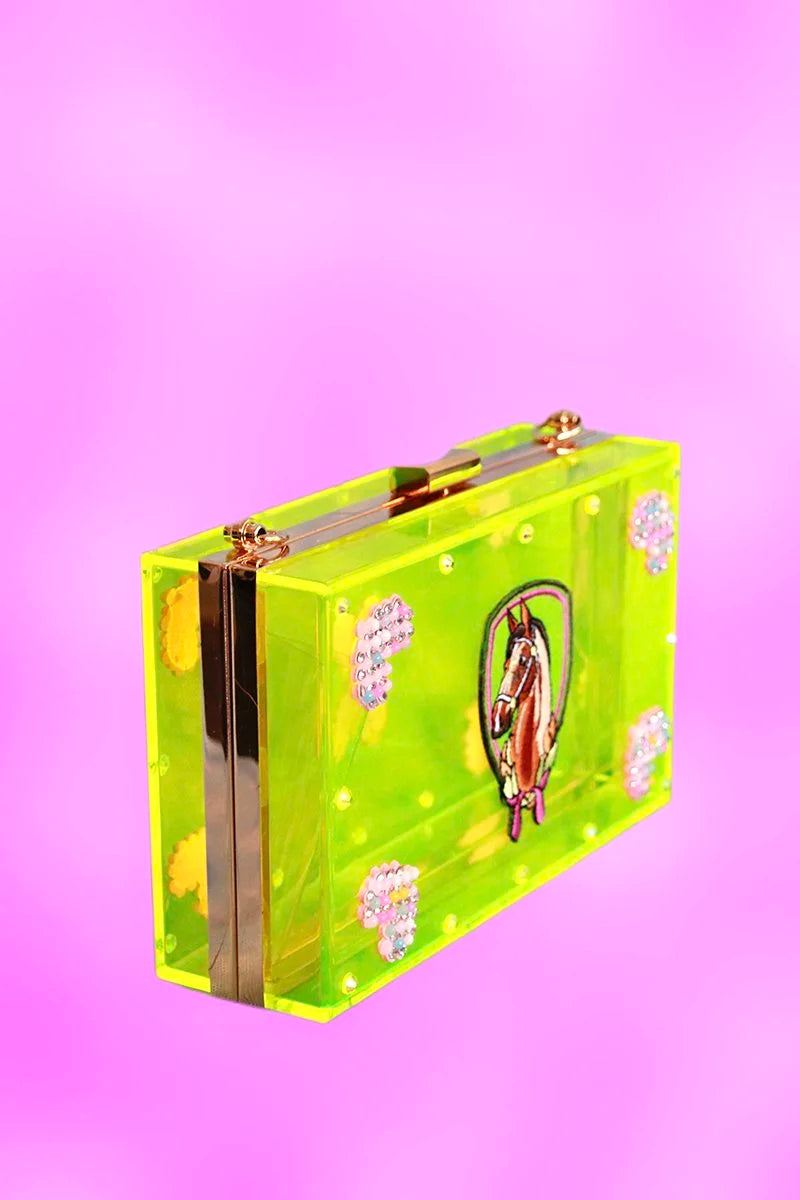 Side angle of neon-green acrylic clutch showcasing gold hardware and embroidered pony emblem.