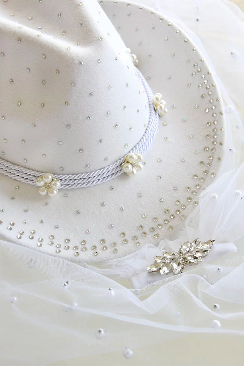 Side angle showing pearl trim and iridescent rhinestones on cowboy hat.