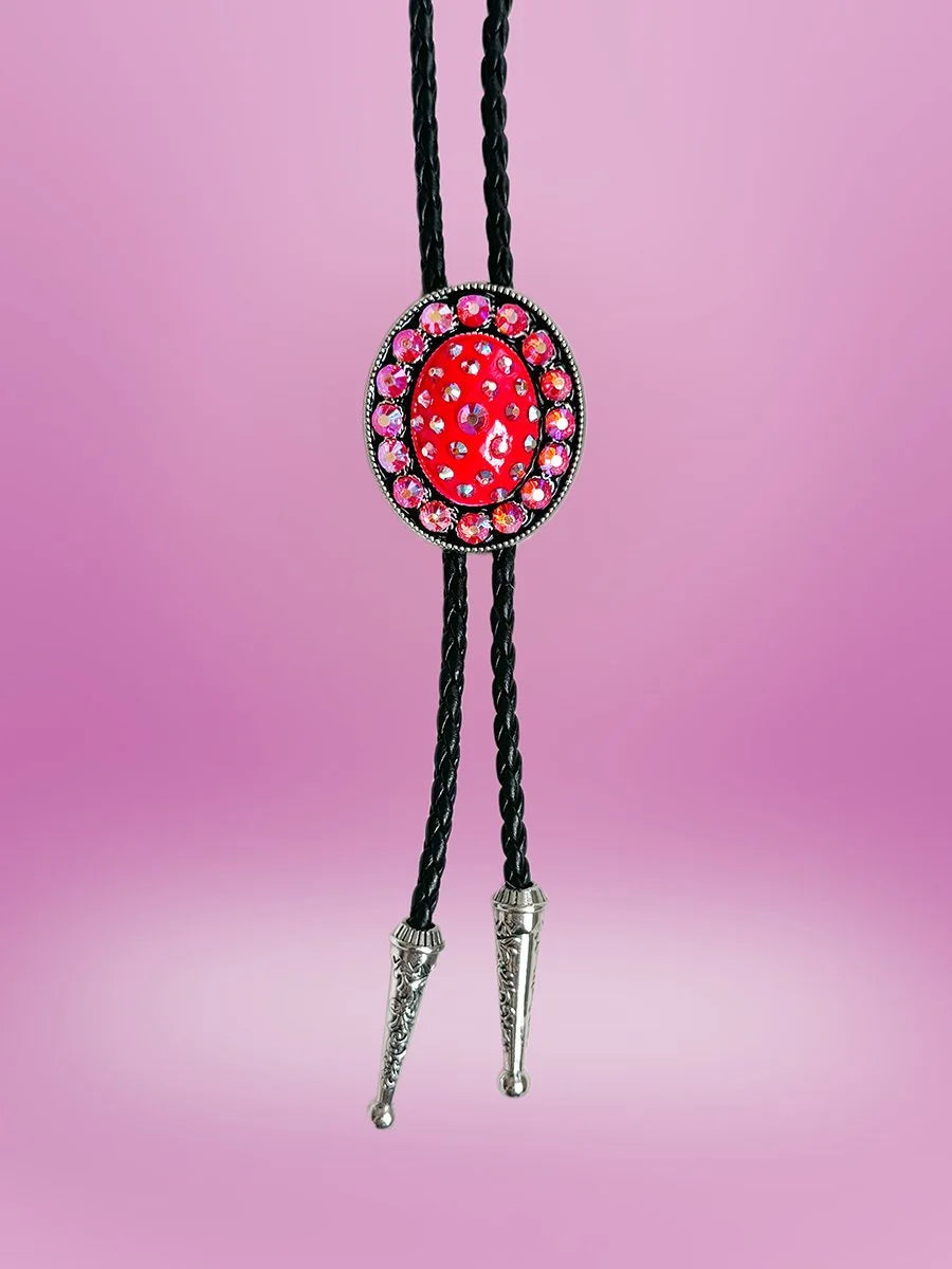Full front view of the Prickly Pear Bolo Tie with deep pink pendant and silver drop tips on black braided rope.