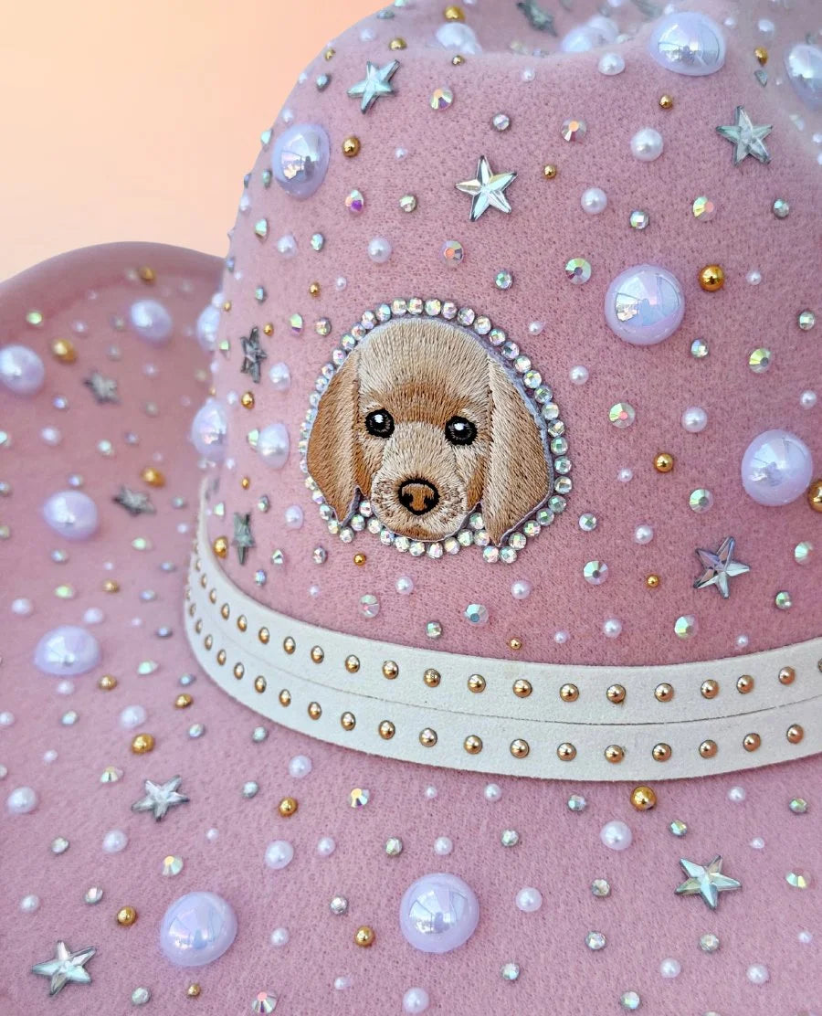Detail of puppy motif and pearl decorations on pink cowboy hat.