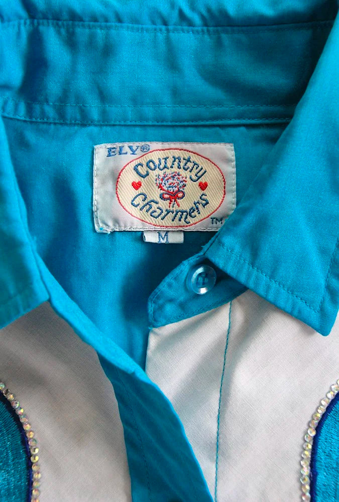 Close-up of vintage Country Charmers shirt label inside teal collar.