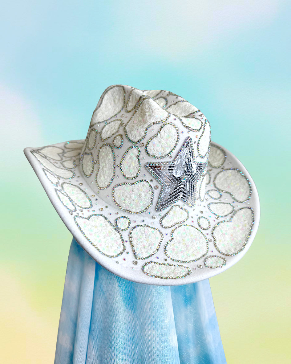 Front-facing white Space Cowgirl cowboy hat with iridescent patches, rhinestones, and a large silver star.