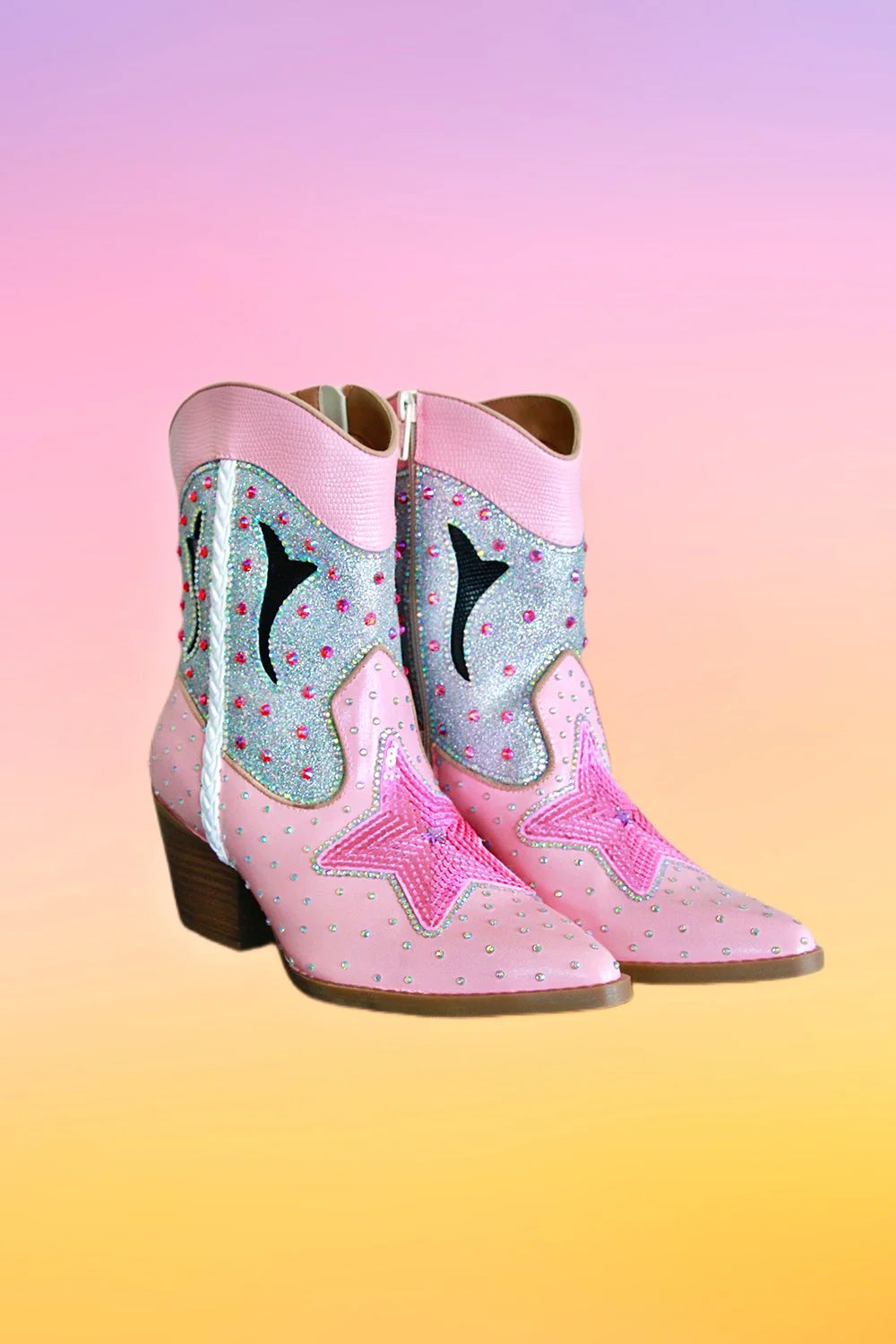 Angled view of pink hand painted ankle cowboy boots with decorative stars and rhinestones.