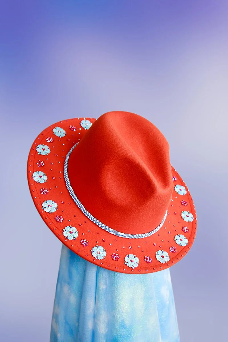 Side profile of orange fedora highlighting the blue glitter underbrim and twisted rope band.