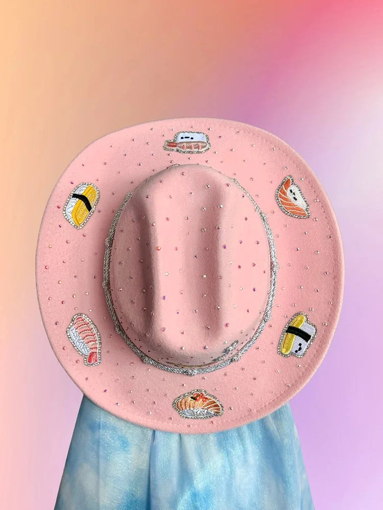 Baby pink sushi cowboy hat with rhinestones and embroidered sushi motifs.