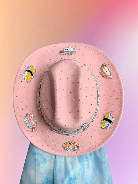 Baby pink sushi cowboy hat with rhinestones and embroidered sushi motifs.