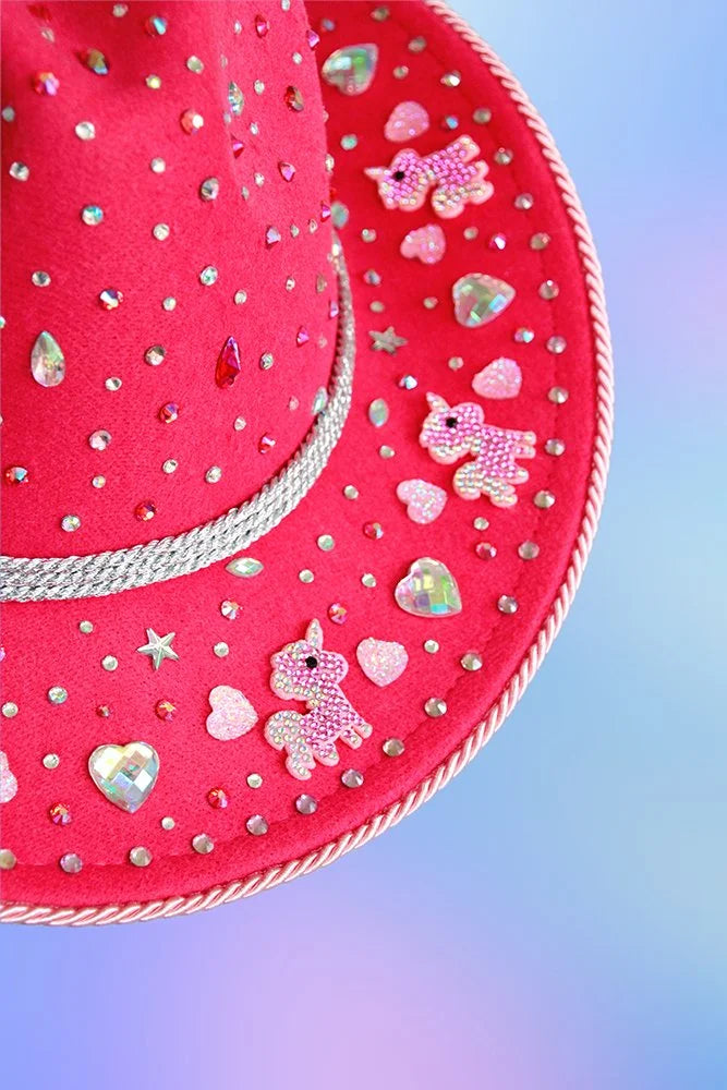 Close-up of pink unicorn appliqués and heart rhinestones on the unicorn dream cowboy hat.