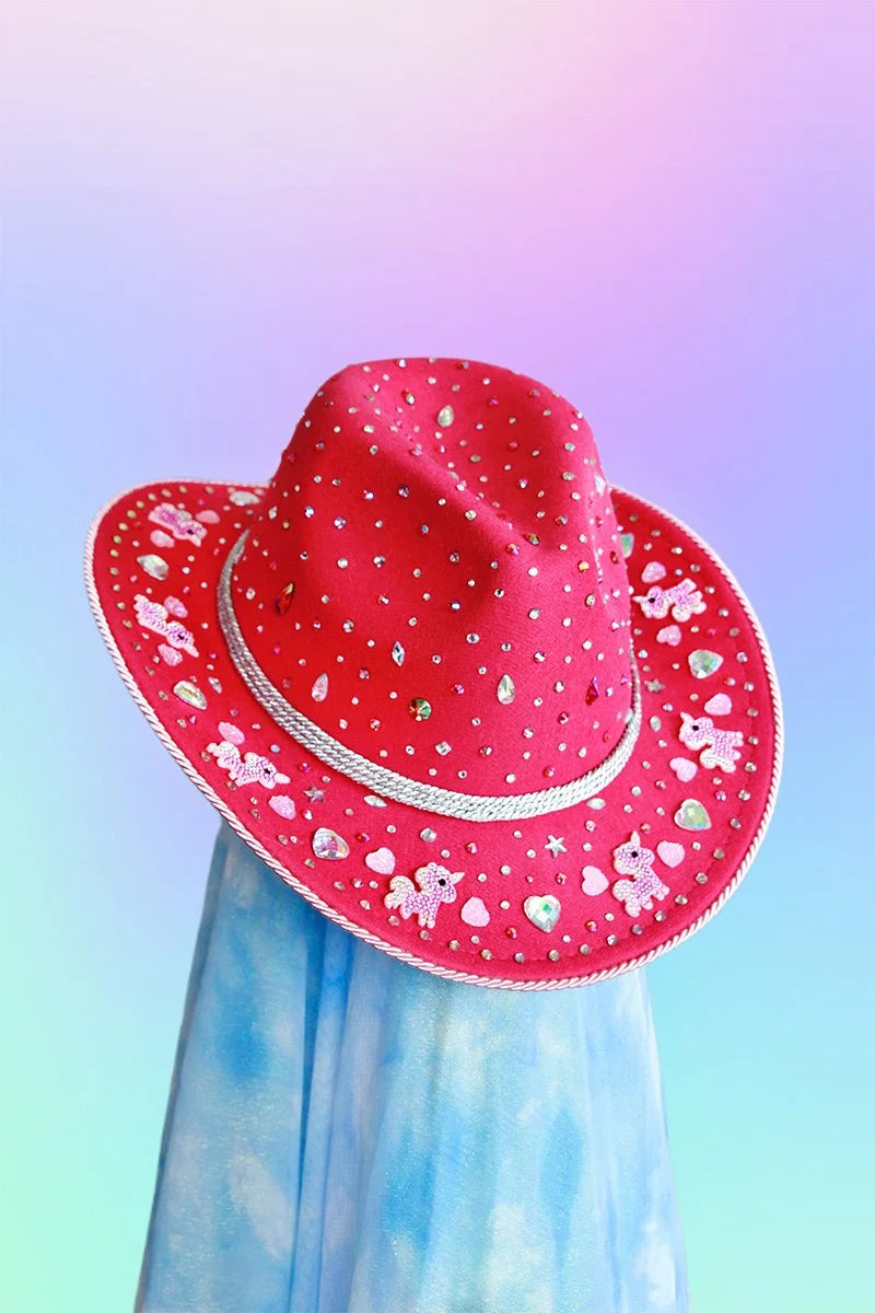 Magenta pink unicorn dream cowboy hat decorated with rhinestones and hearts, front view.