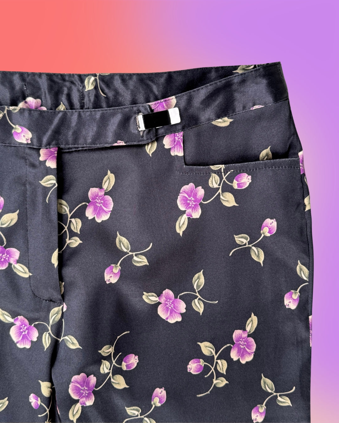 Close-up of black satin fabric with purple floral print on vintage Parisian capri pants.